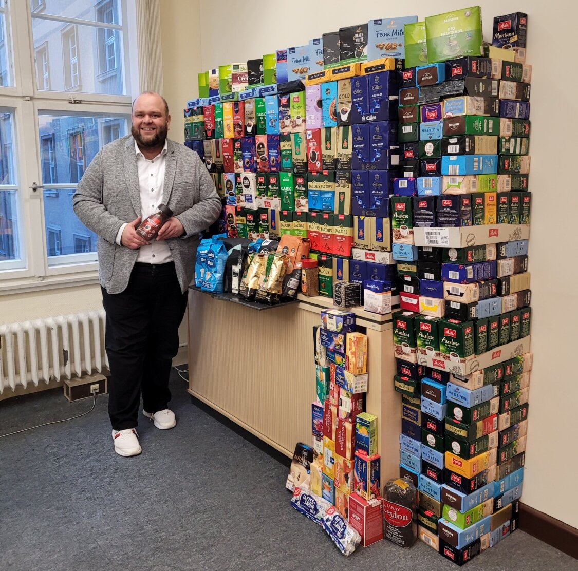 Bezirksstadtrat Matthias Steuckardt mit dem gesammelten Kaffee im Rathaus Tempelhof für die Kaffeewette 2025