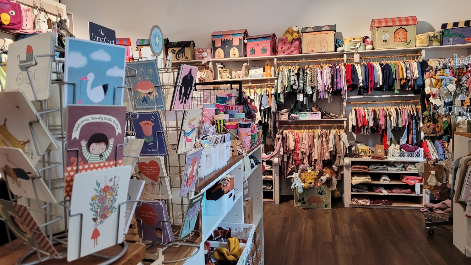 In einem Laden sind viele Kindersachen, Spielzeug und Karten.