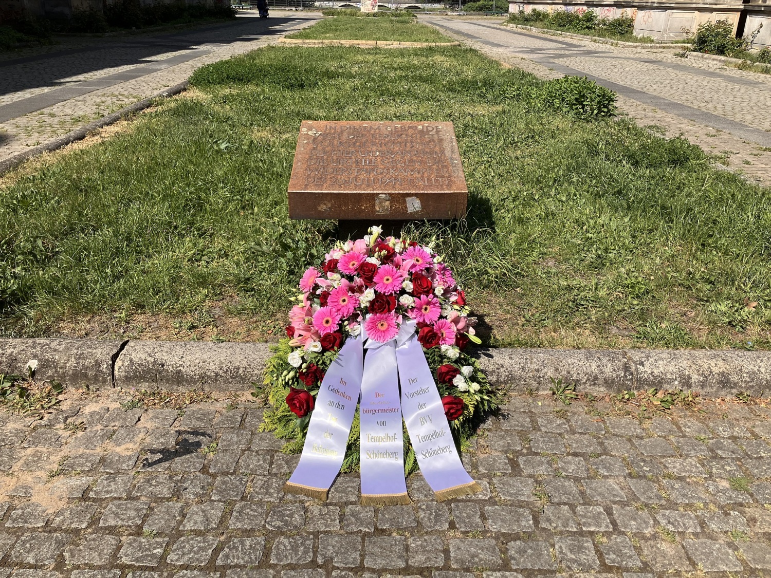 Ein Kranz liegt vor einem Gedenkstein.