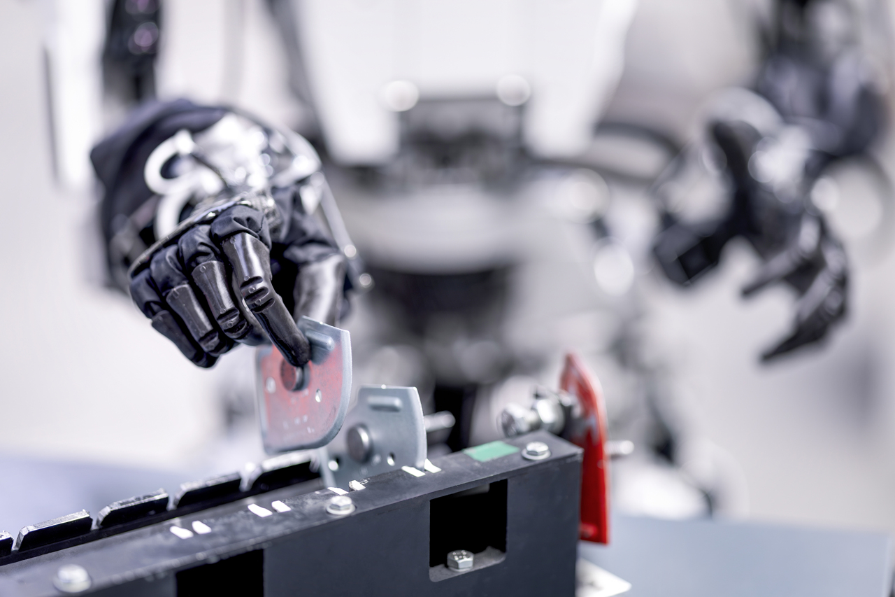 Nahaufnahme von einer Roboterhand, die einen Gegenstand nimmt.