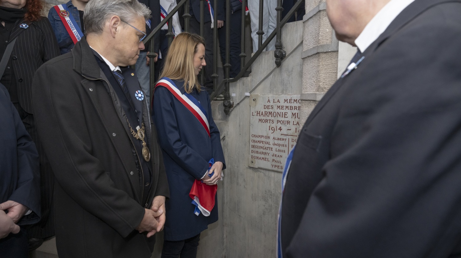 Personen schauen auf eine Gedenktafel.