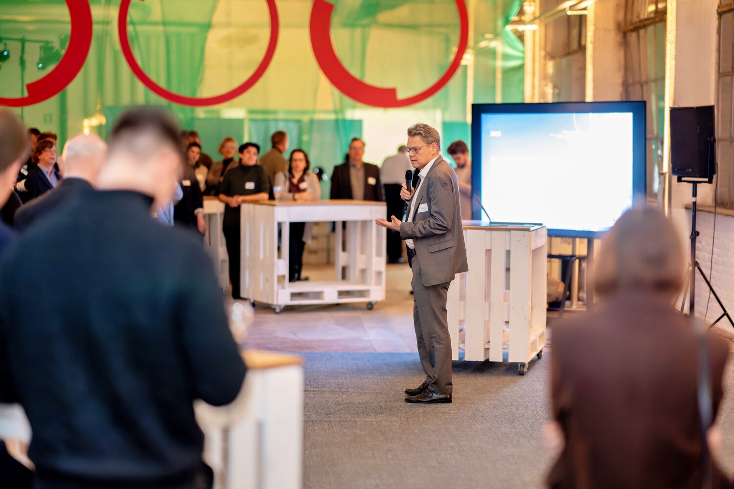 Ein Mann hält vor mehreren Menschen einen Vortrag