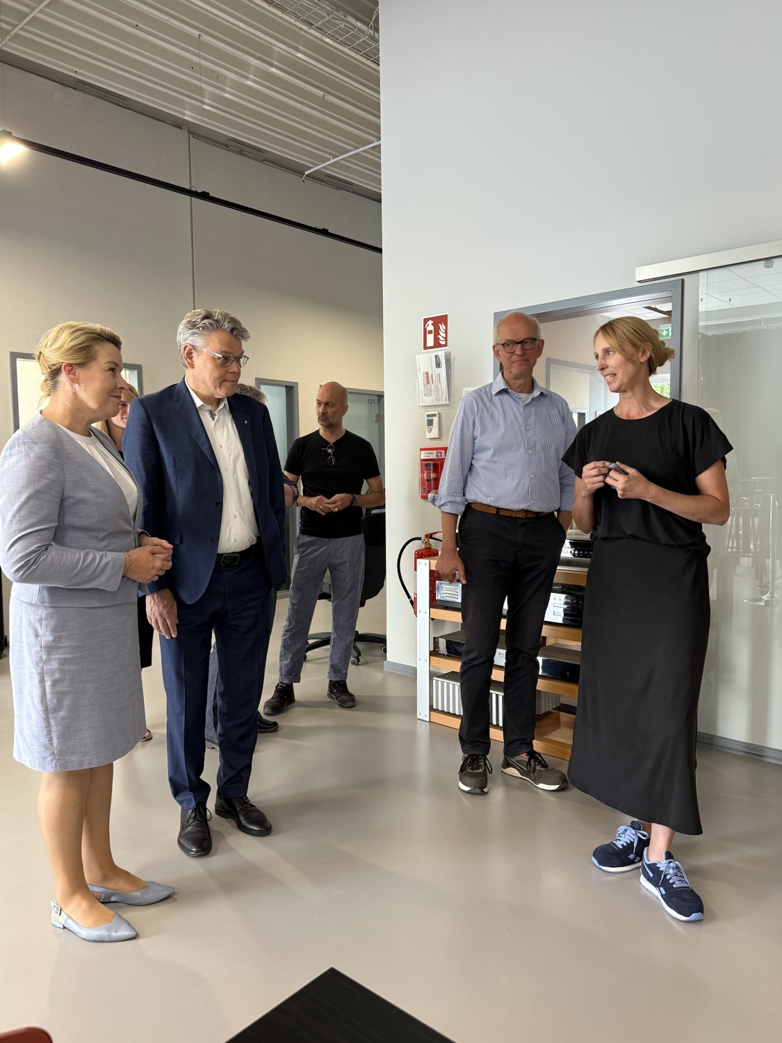 Personen stehen in einer Halle und unterhalten sich.