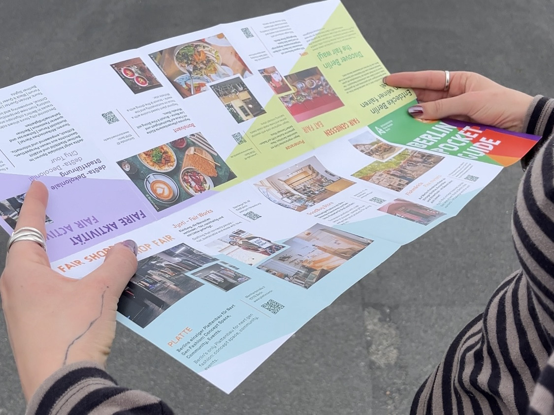 Eine Person hält eine auseinandergefaltete Broschüre mit Informationen in den Händen.