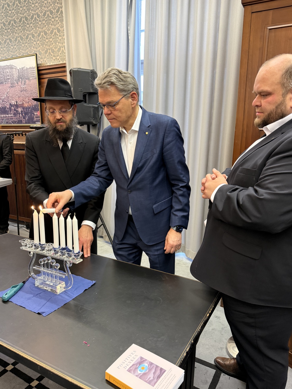 Stellvertretender Bezirksbürgermeister Matthias Steuckardt, Rabbiner Yehuda Teichtal und Bezirksbürgermeister Jörn Oltmann entzünden Kerzen