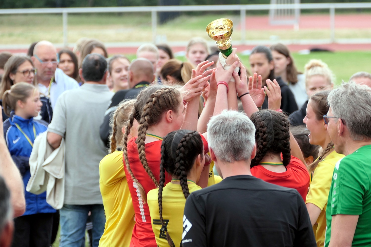 Mädchen halten gemeinsam einen Pokal in die Höhe.