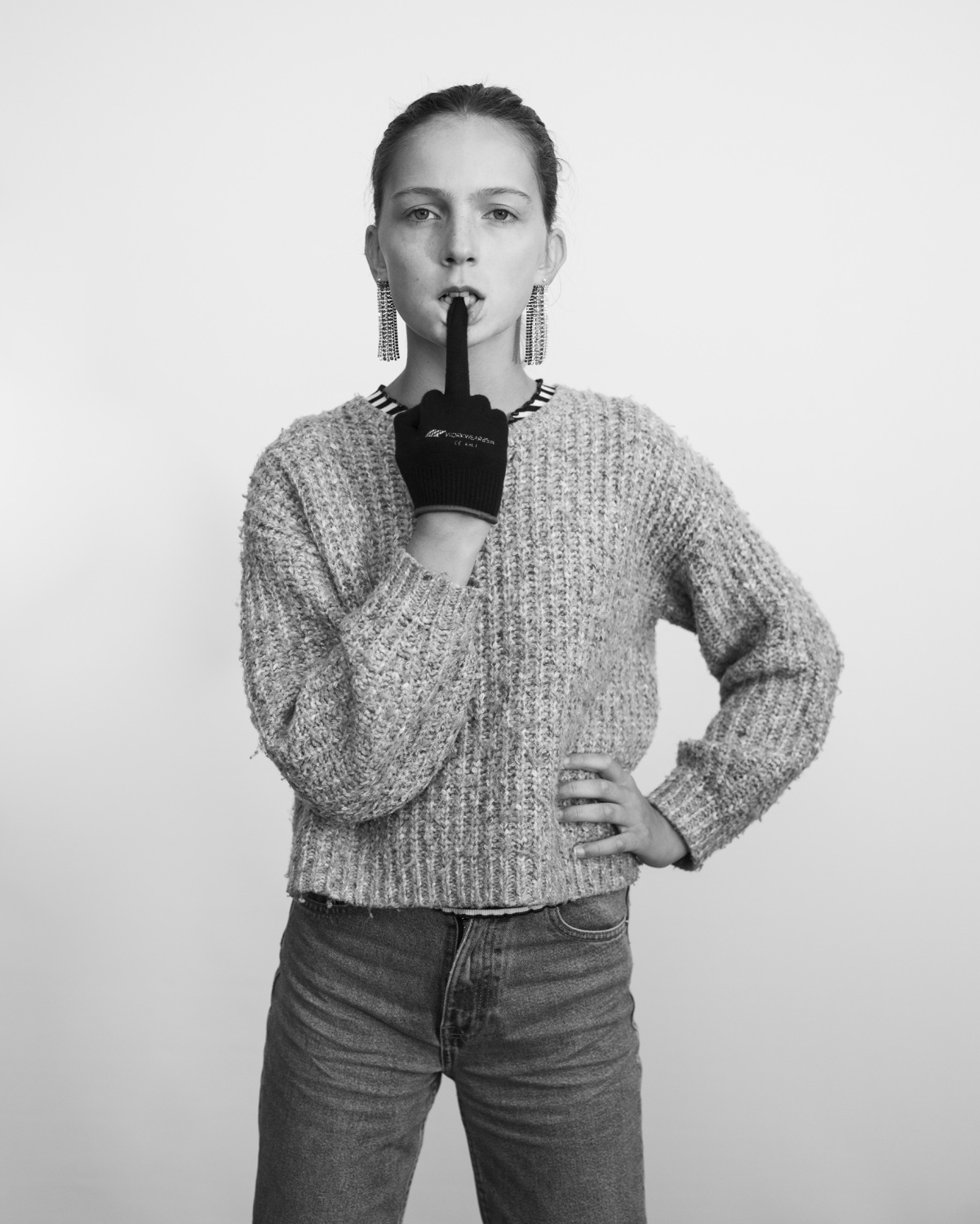 Schwarzweißfotografie von einer Frau, die einen Handschuh trägt und mit ihrem Mittelfinger ihre untere Lippe nach unten zieht