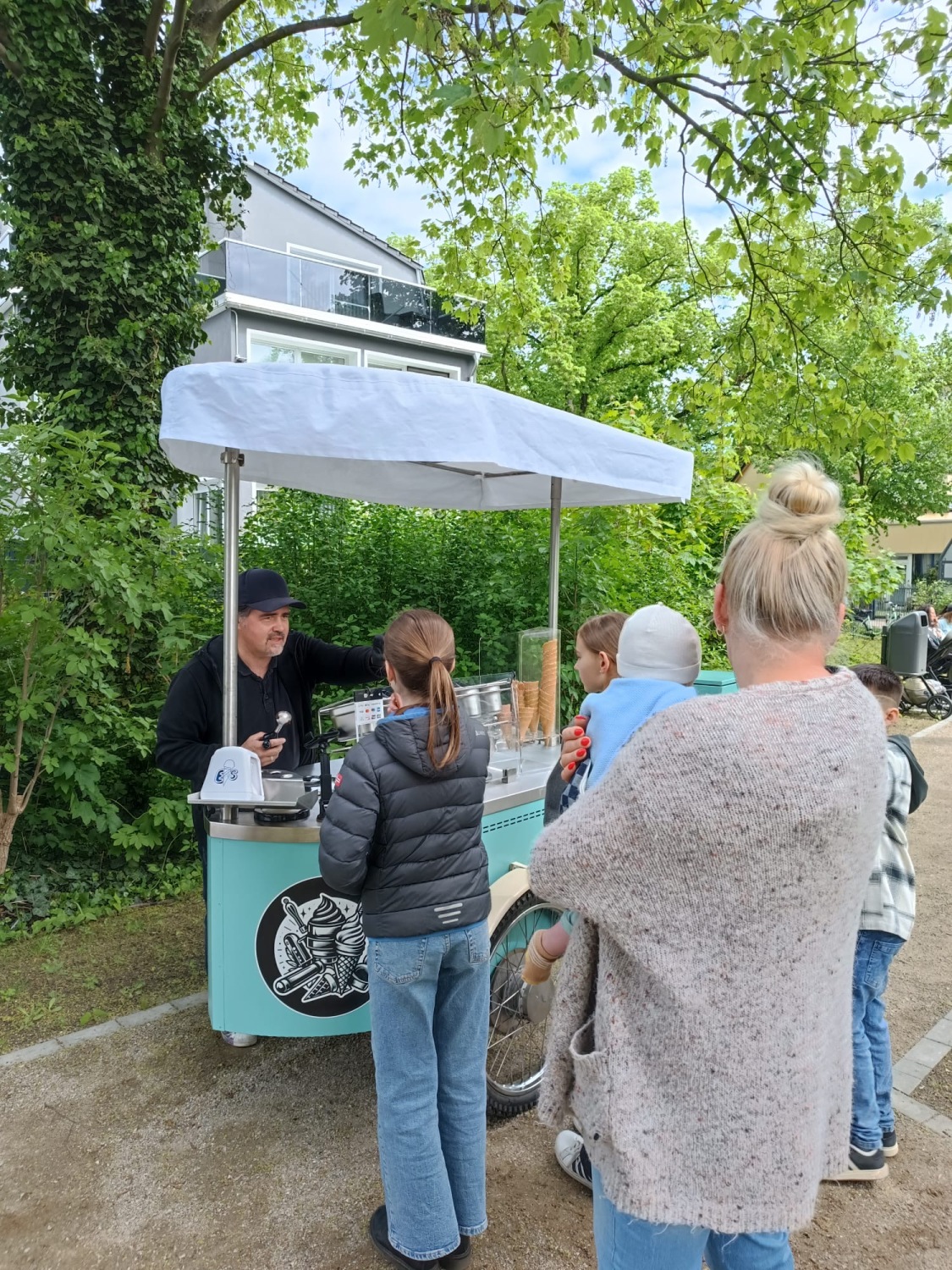 Menschen stehen an einem mobile Eisstand an.