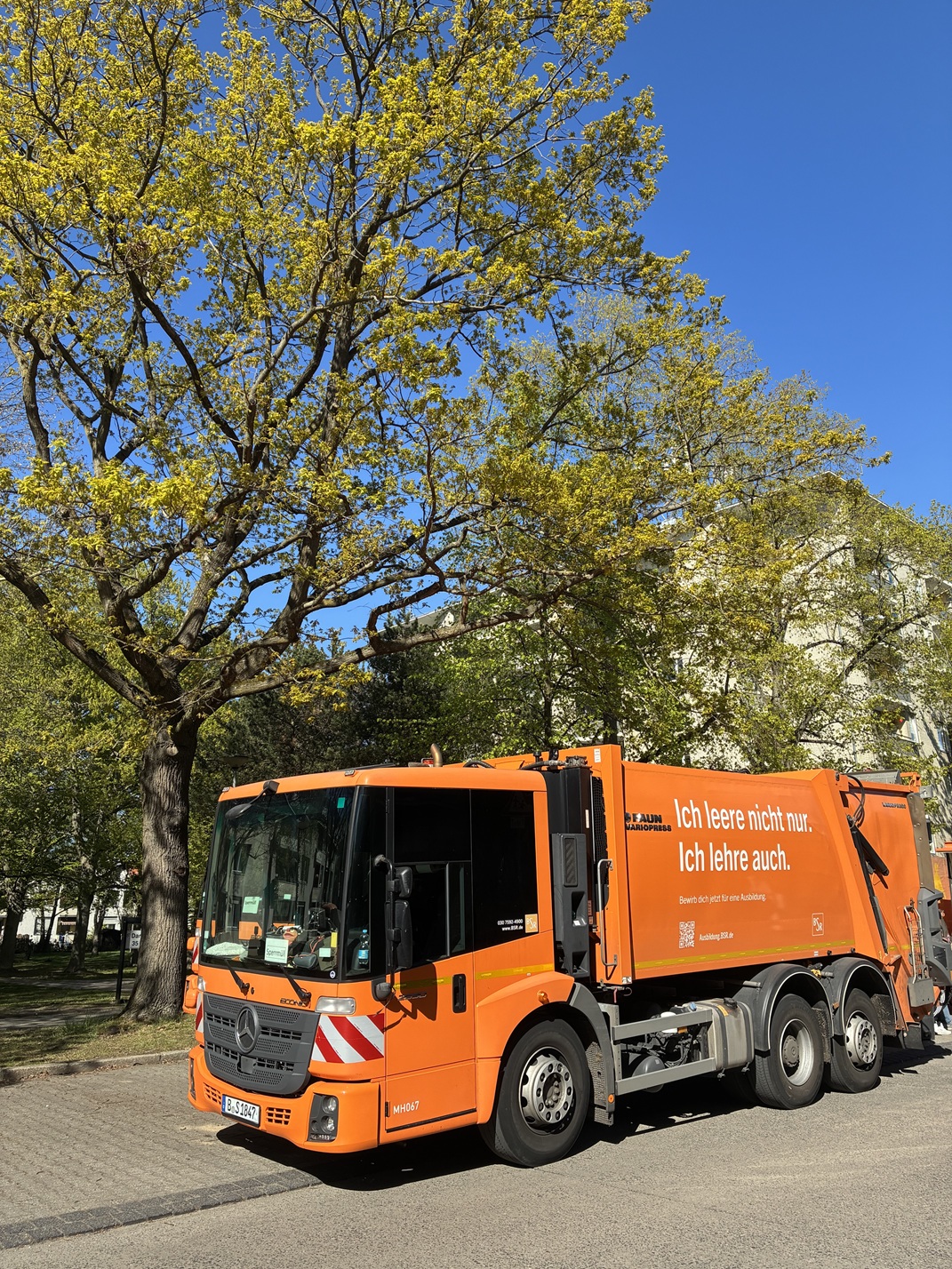 Ein Wagen der Berliner Stadtreinigung steht am Straßenrand.