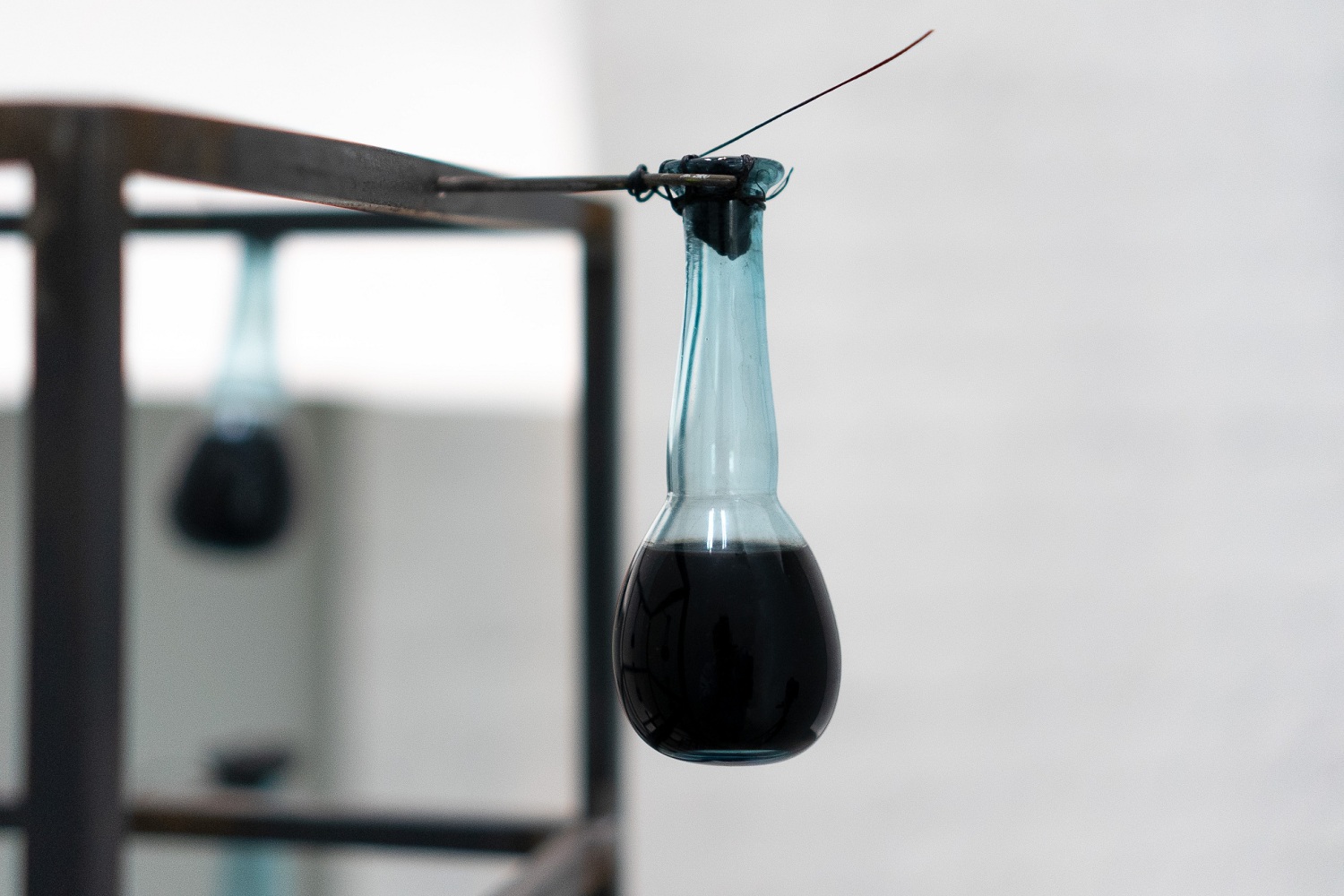 ein kleines Glas mit Tinte an einem Metallgerüst