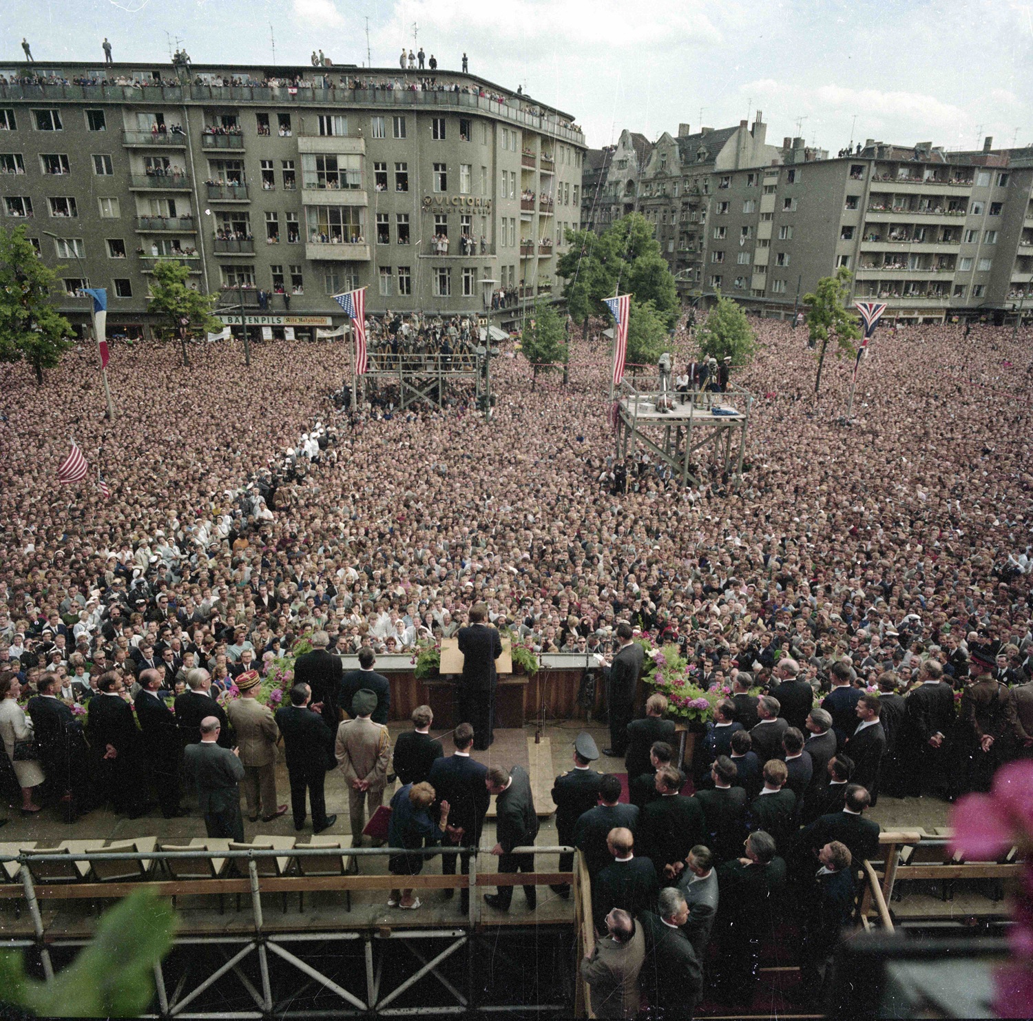 26. Juni 1963: Präsident John F. Kennedy steht auf einer Tribüne, die auf den Stufen des Schöneberger Rathauses in West-Berlin errichtet wurde. Eine Menschenmenge beobachtet den Präsidenten (mit dem Rücken zur Kamera), während er auf dem Rudolf-Wilde-Platz in West-Berlin, Bundesrepublik Deutschland, seine „Ich bin ein Berliner“-Rede hält.