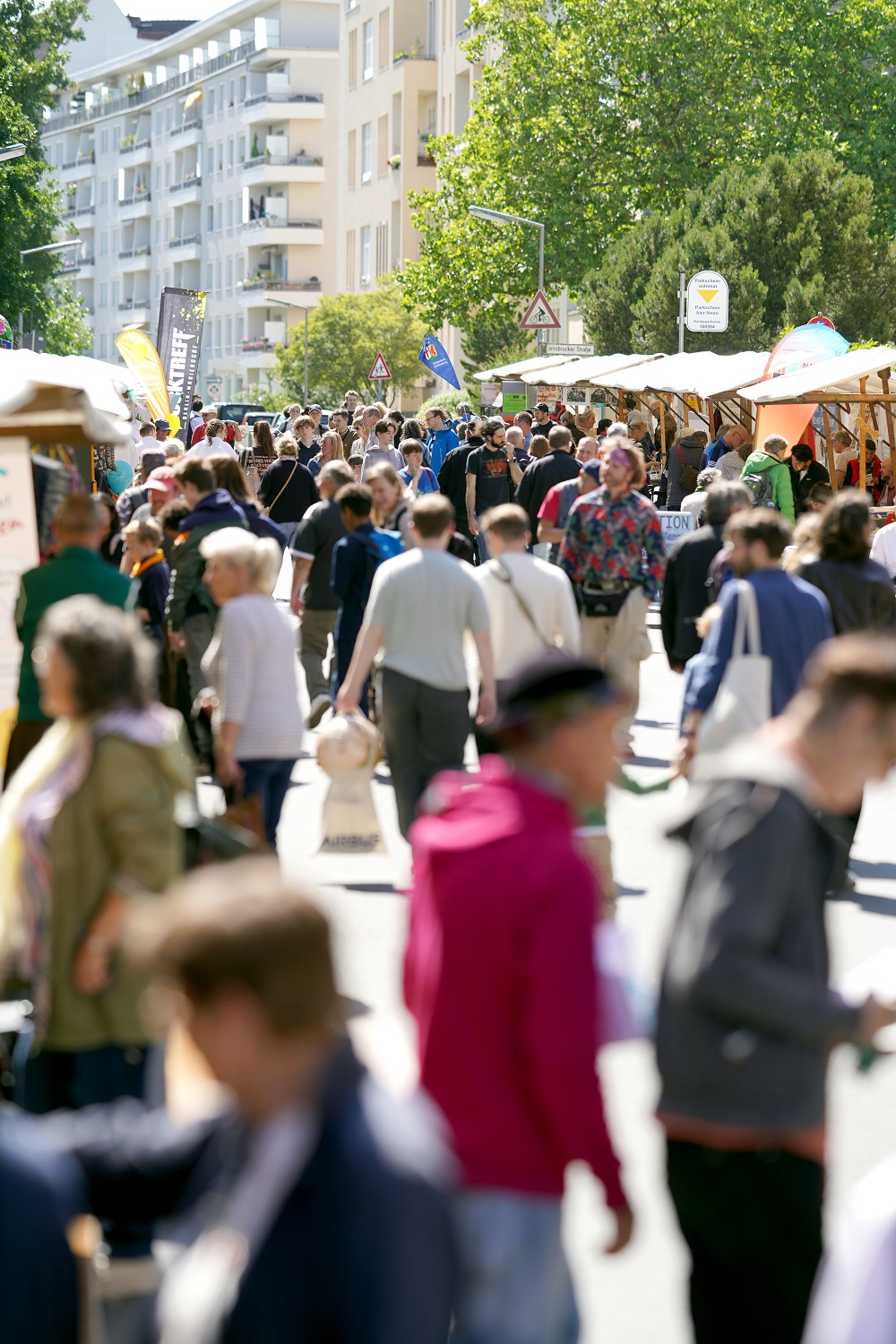 viele Menschen laufen zwischen Marktständer umher