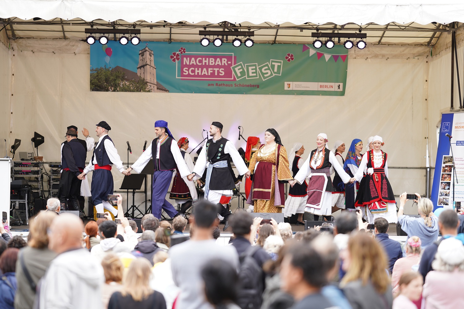 eine Tanzgruppe in Folklore-Kleidung auf einer großen Bühne