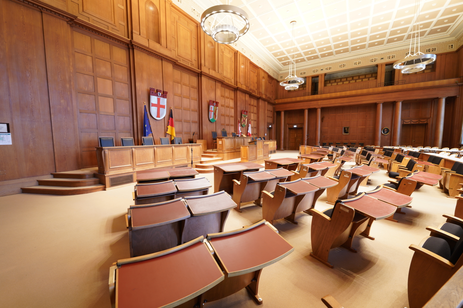Großer Saal mit alten Stühlen, die richtung Podest gerichtet sind