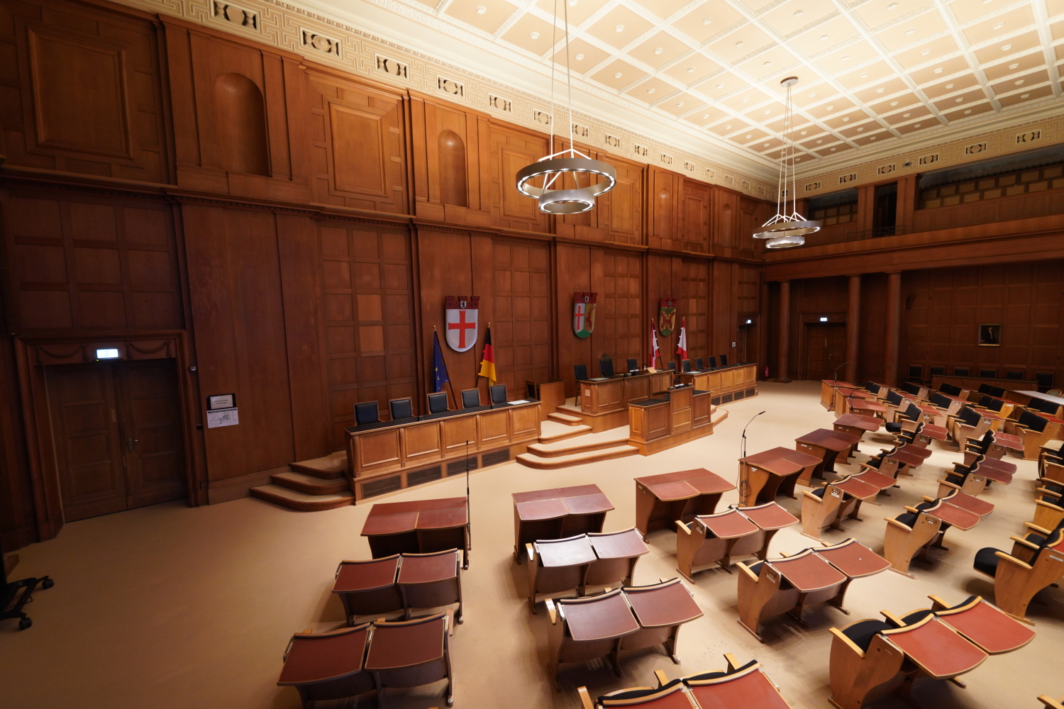 Großer Saal mit alten Stühlen, die richtung Podest gerichtet sind