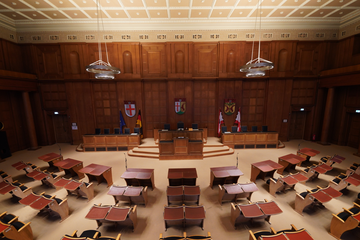 Großer Saal mit alten Stühlen, die richtung Podest gerichtet sind