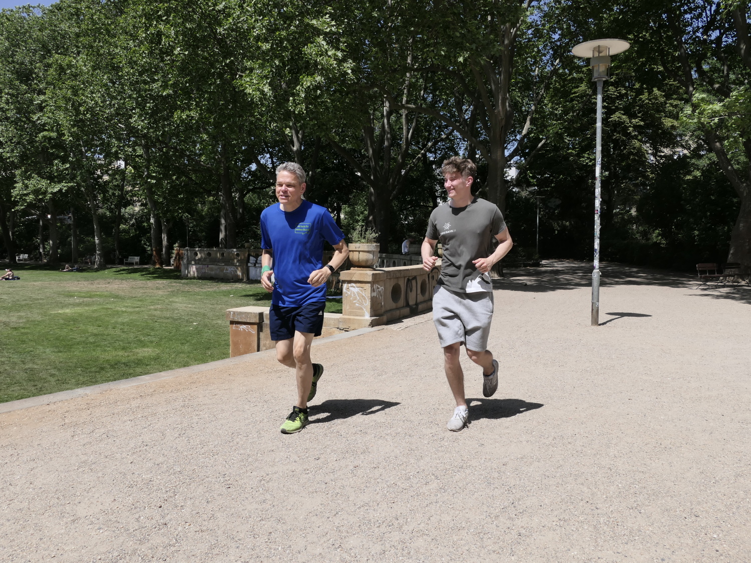 Zwei Erwachsene joggen über einen Weg