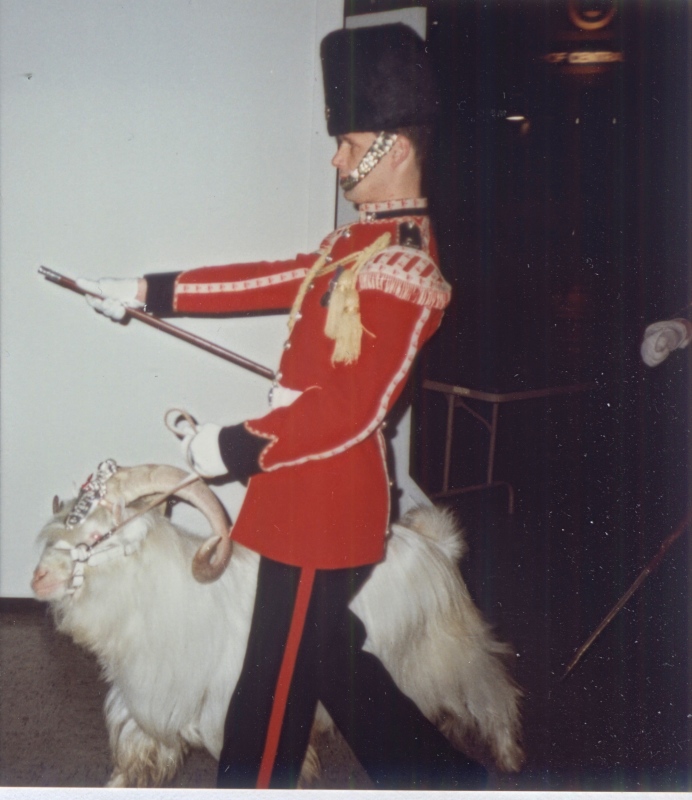 Ein Mann in Soldatenuniform führt einen Ziegenbock