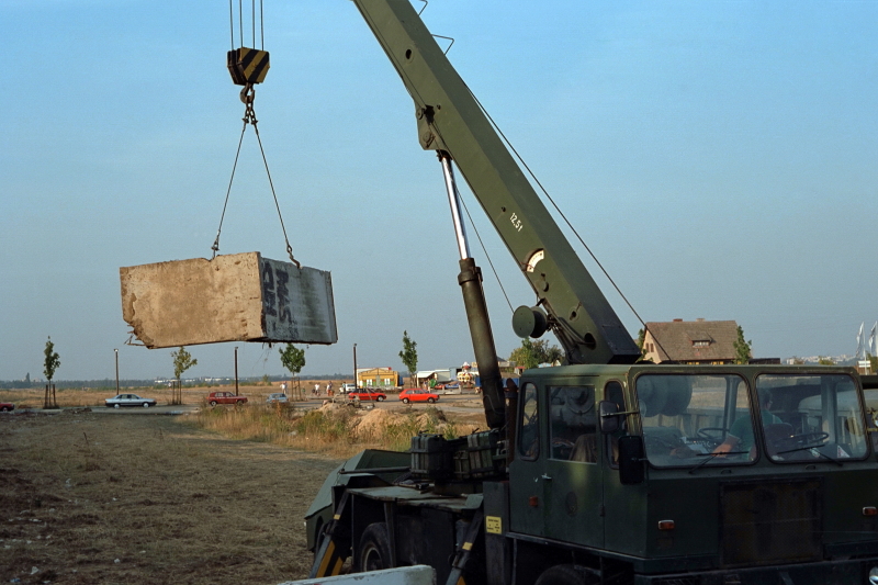 ein Kran transportiert eine Betonplatte