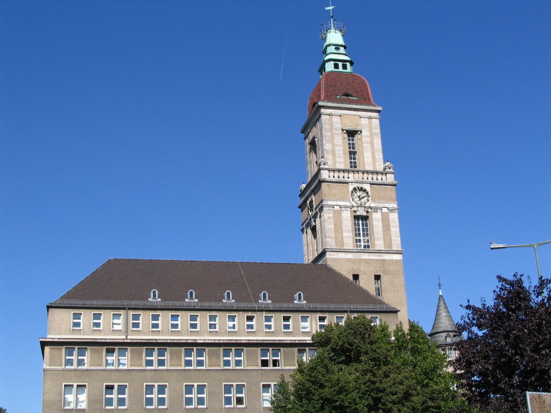 Ein großes Gebäude mit Turm vor einem klaren blauen Himmel.