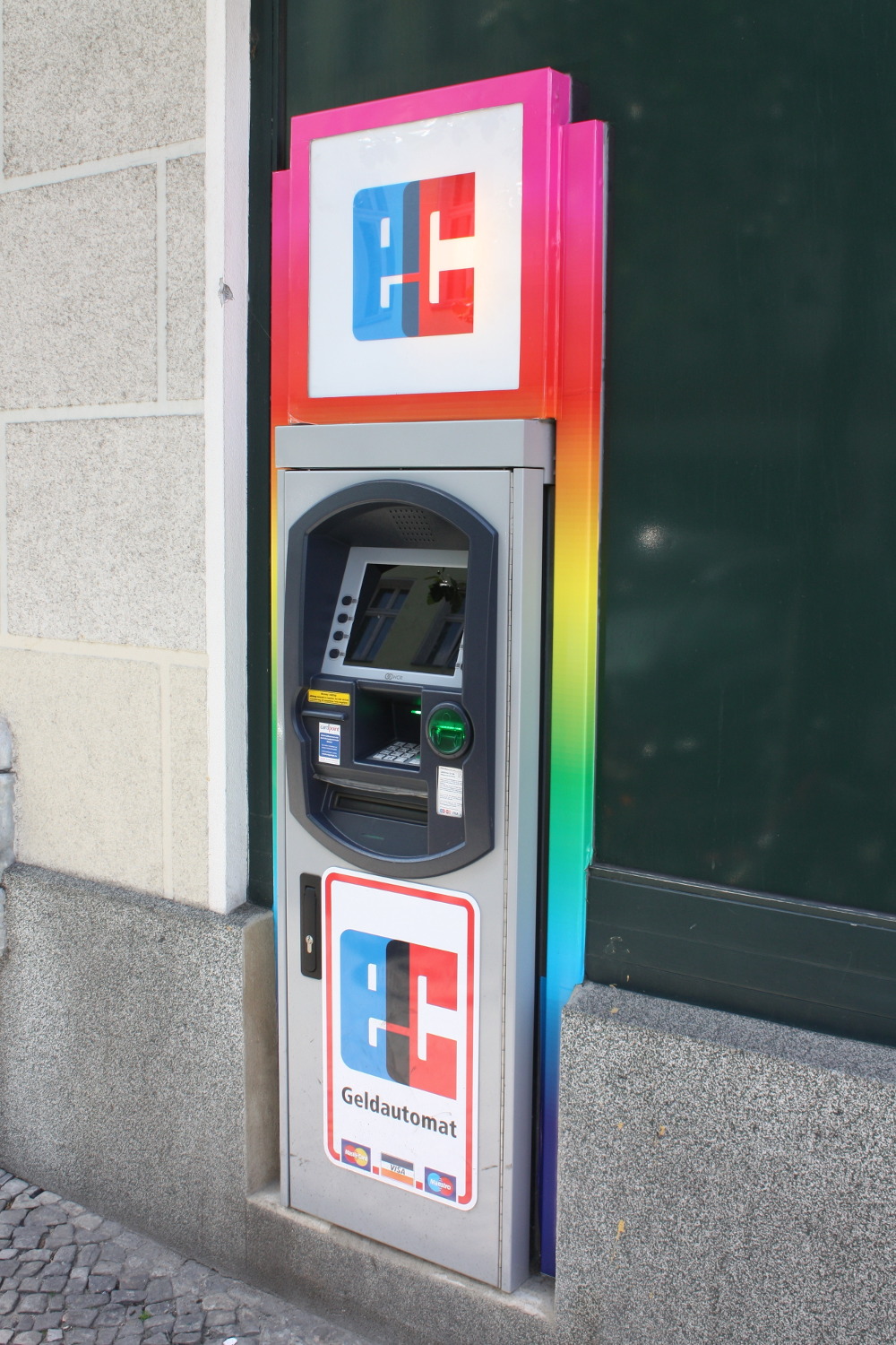 Geldautomat mit Regenbogenfarben im Hintergrund