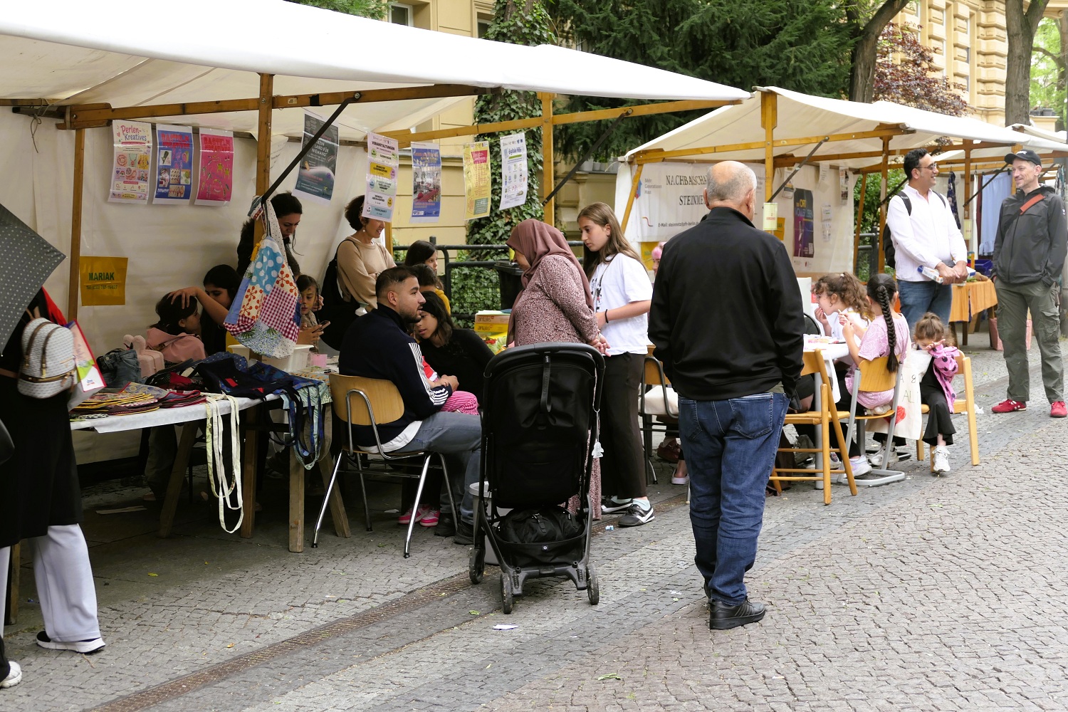 Mehrere Marktstände an denen sich Menschen unterhalten