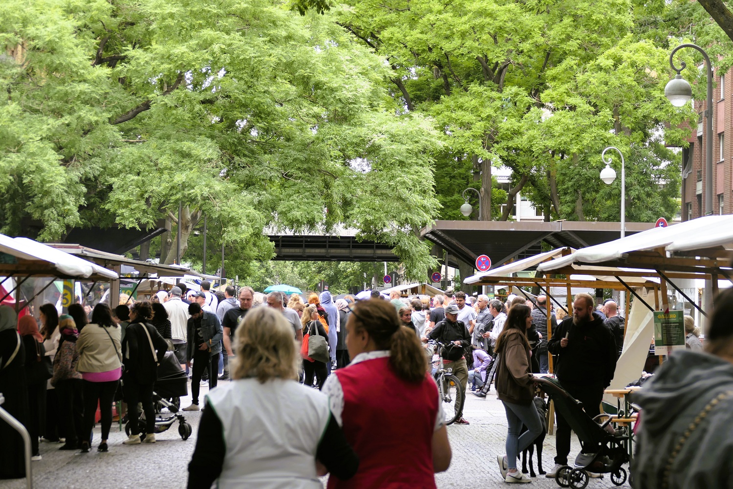 Blick auf ein Straßenfest Marktstände und Menschen sind verteilt