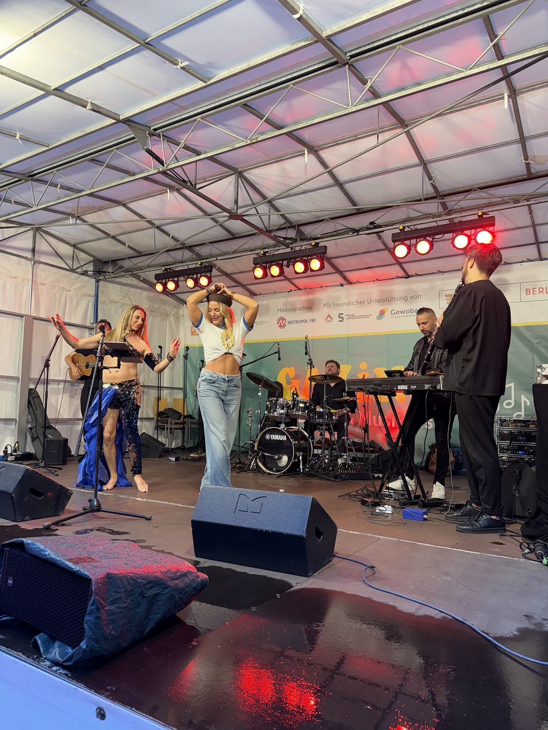 Zeynep Avci tanzt auf einer Bühne mit mehreren Menschen