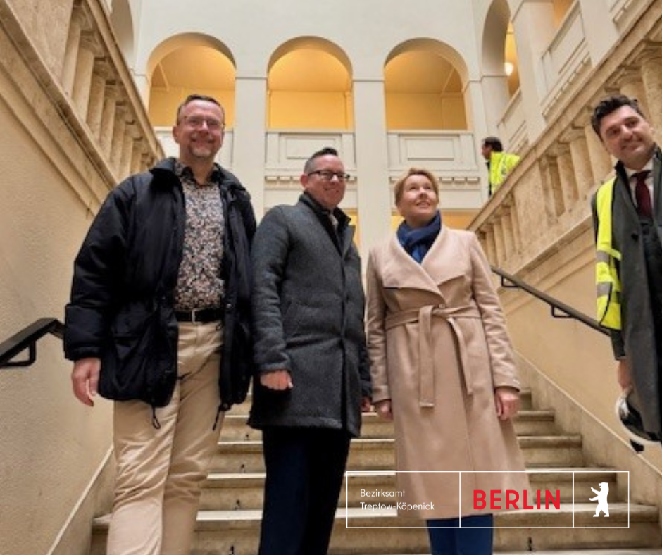 Bezirkstour Giffey - Herr Schmohl, Herr Igel und Fri Giffey stehen im Trreppenhaus des Peter Behrens Baus