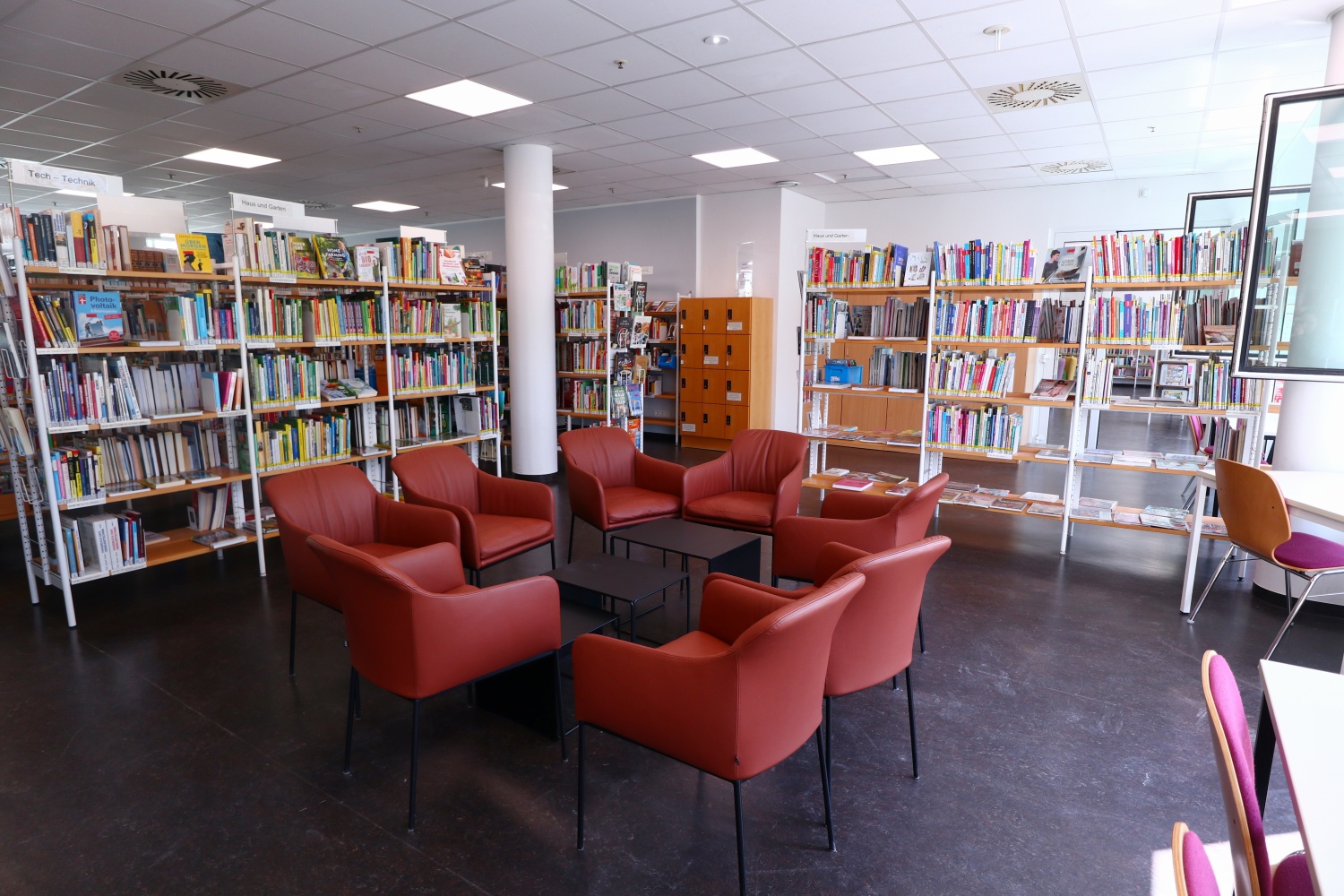 Sitzgruppe in der Bibliothek mit roten Sesseln