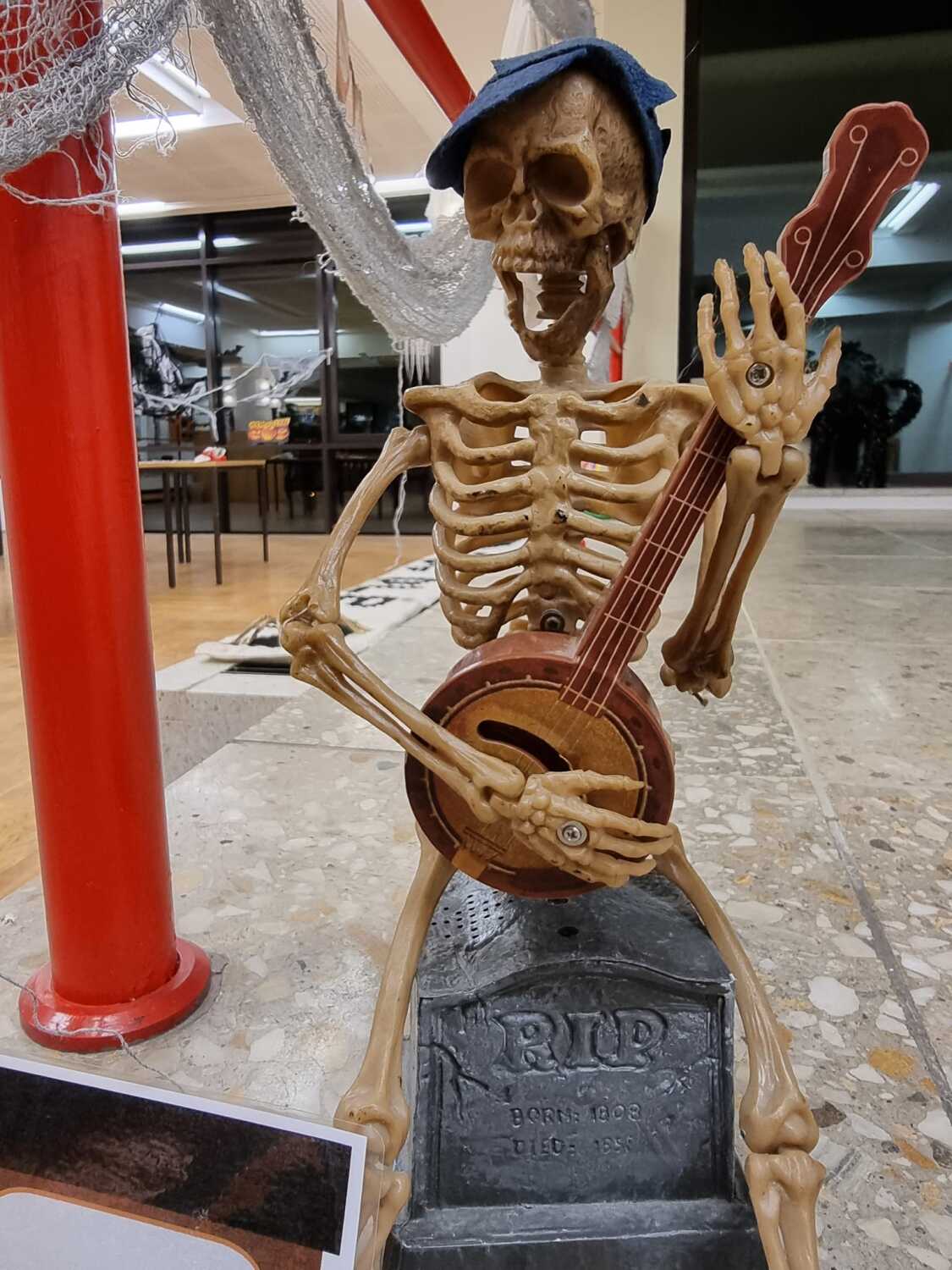 Skelett sitzt auf Stufen und spielt Banjo