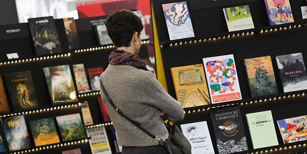Frau betrachtet Bücher auf Buchmesse