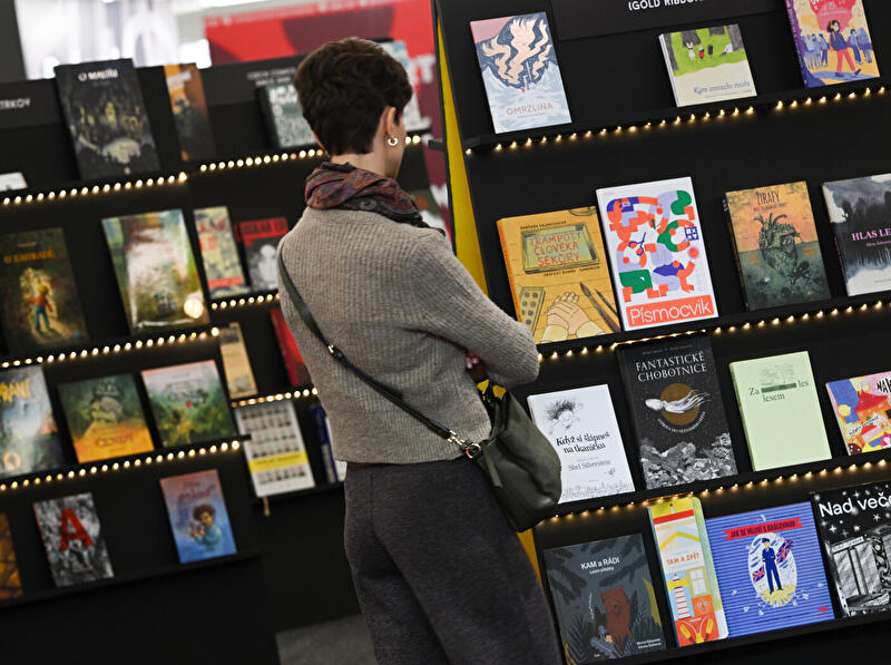 Frau betrachtet Bücher auf Buchmesse