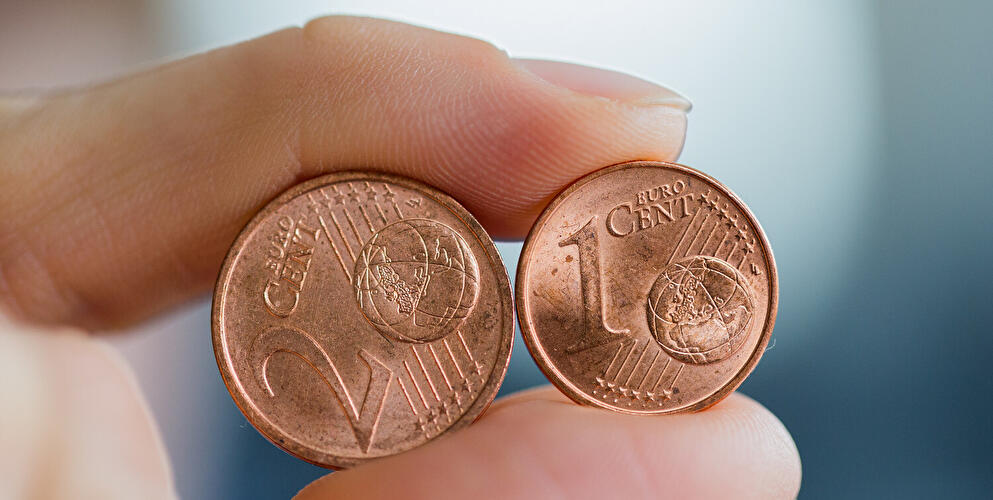 1 und 2 Cent zwischen Fingern