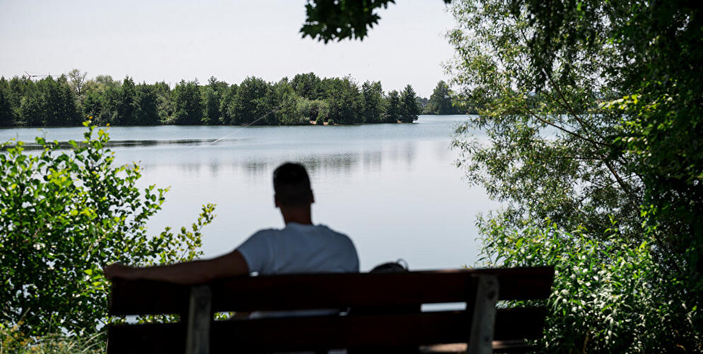 Mann auf Bank mit Blick auf See