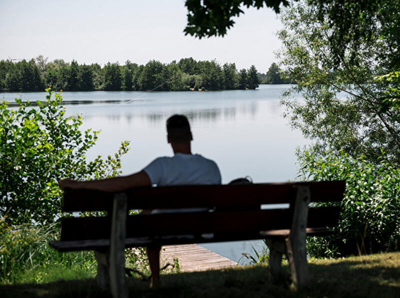 Mann auf Bank mit Blick auf See
