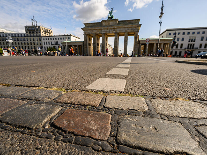 An der Stelle, wo zu DDR-Zeiten die Berliner Mauer stand, sind vor dem Brandenburger Tor Pflastersteine, die an die Mauerzeiten errinern.