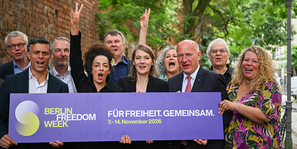 Teilnehmende einer Demokratieinitiative präsentieren in Berlin ein Schild mit der Aufschrift „Für Freiheit. Gemeinsam.“ und werben für die Berlin Freedom Week 2026.