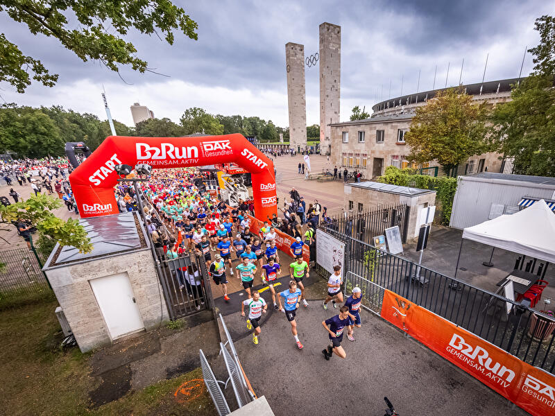 Participants in the B2Run Berlin run through a gate at the Olympic Stadium