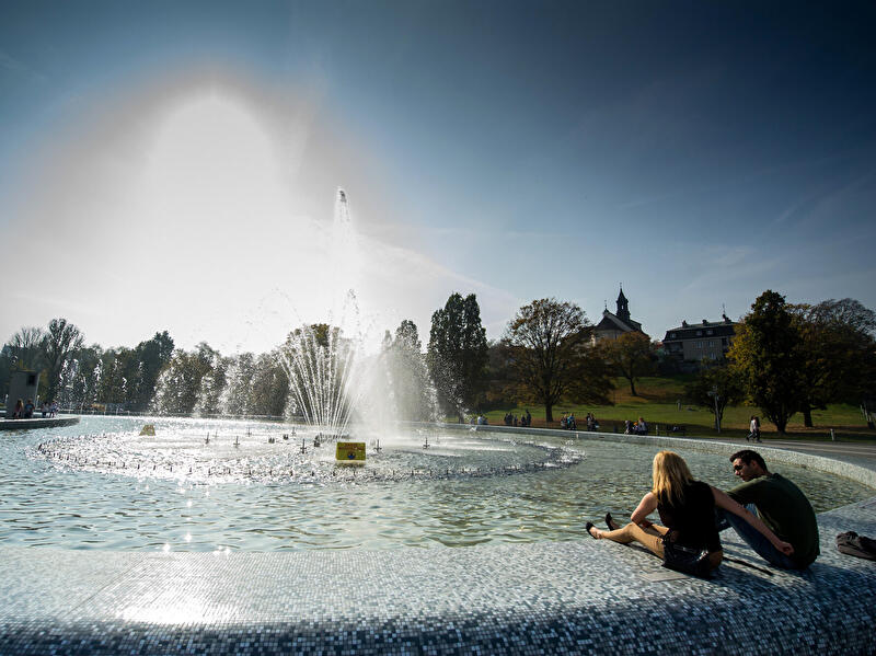 Eine Mann und eine Frau entspannen sich in an einem Springbrunnen