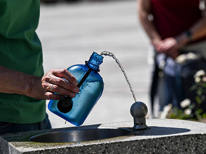 Ein Mann nutzt einen Wasserspender, um seine Trinkflasche aufzufüllen.