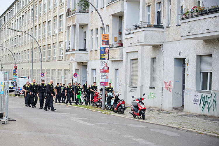 Eine Gruppe von Polizeikräften geht eine Wohnstraße in Berlin-Neukölln entlang, im Rahmen der Evakuierung während der Bombenentschärfung.