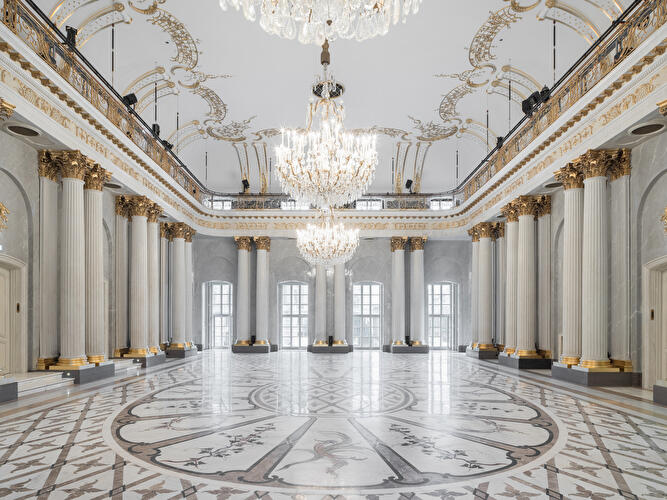 Das elegante Voyer der Staatsoper Unter den Linden mit Säulen, Kronleuchtern und kunstvoll gestaltetem Marmorboden.
