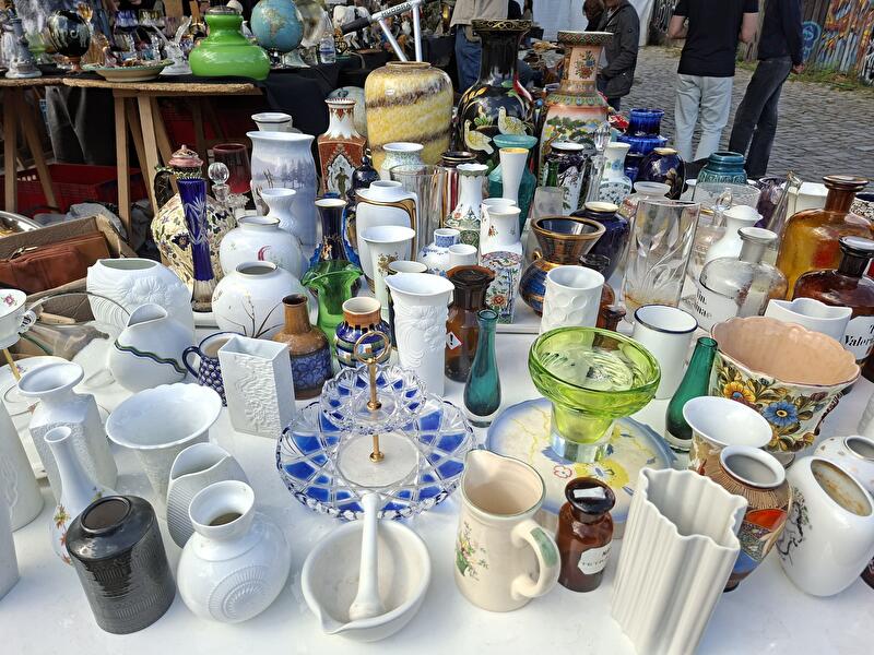 Auf dem Flohmarkttisch werden Vasen zum Verkauf angeboten.