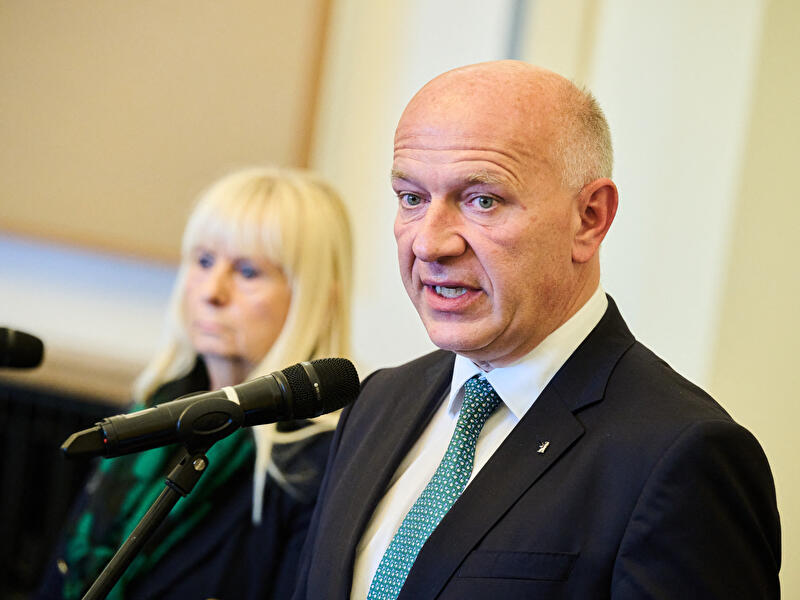 Der Regierende Bürgermeister von Berlin Kai Wegner spricht in ein Mikrofon bei einem Statement zum Hackerangriff, im Hintergrund die Berliner Innensenatorin Iris Spranger.