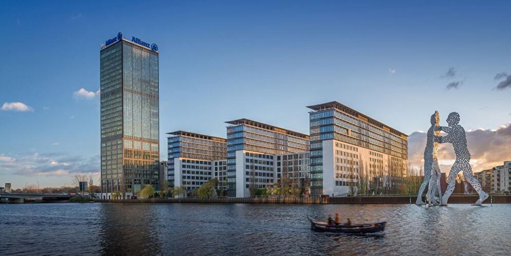 Blick über die Spree auf die Gebäude Treptower, Trias und der Skulptur „Molecule Man“ in Berlin-Treptow