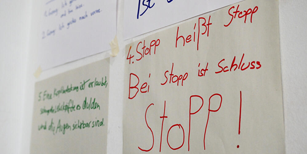 Handschriftliche Regeln an einer Wand, darunter der Hinweis "Bei Stopp ist Schluss".