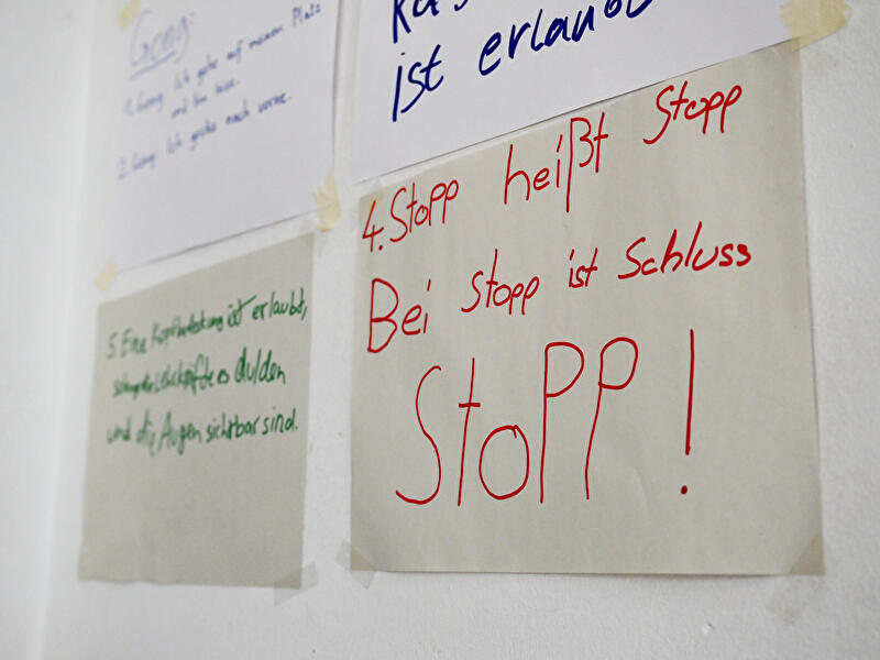 Handschriftliche Regeln an einer Wand, darunter der Hinweis "Bei Stopp ist Schluss".
