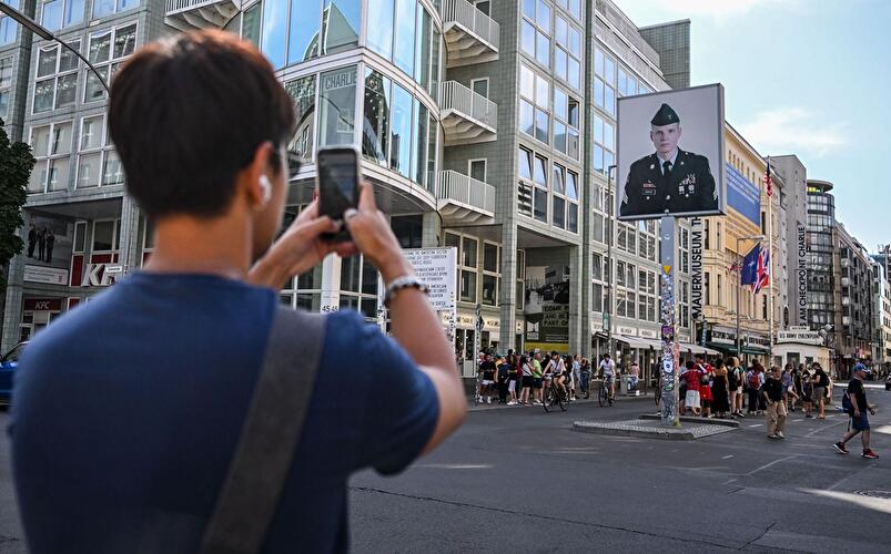 Checkpoint Charlie mit Kontrollschild, Museum und zahlreichen Besucherinnen und Besuchern.