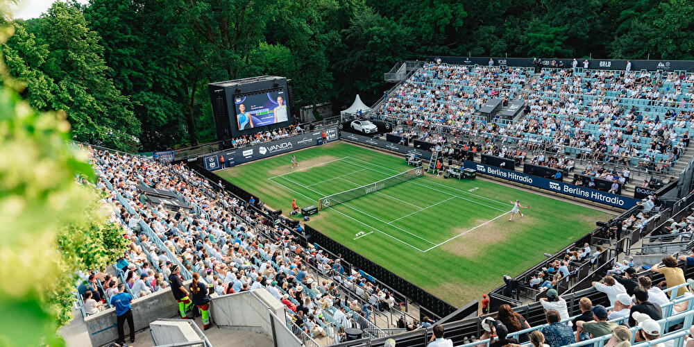 Zuschauer:innen verfolgen ein Match auf dem Rasenplatz der Berlin Tennis Open aus der Vogelperspektive.